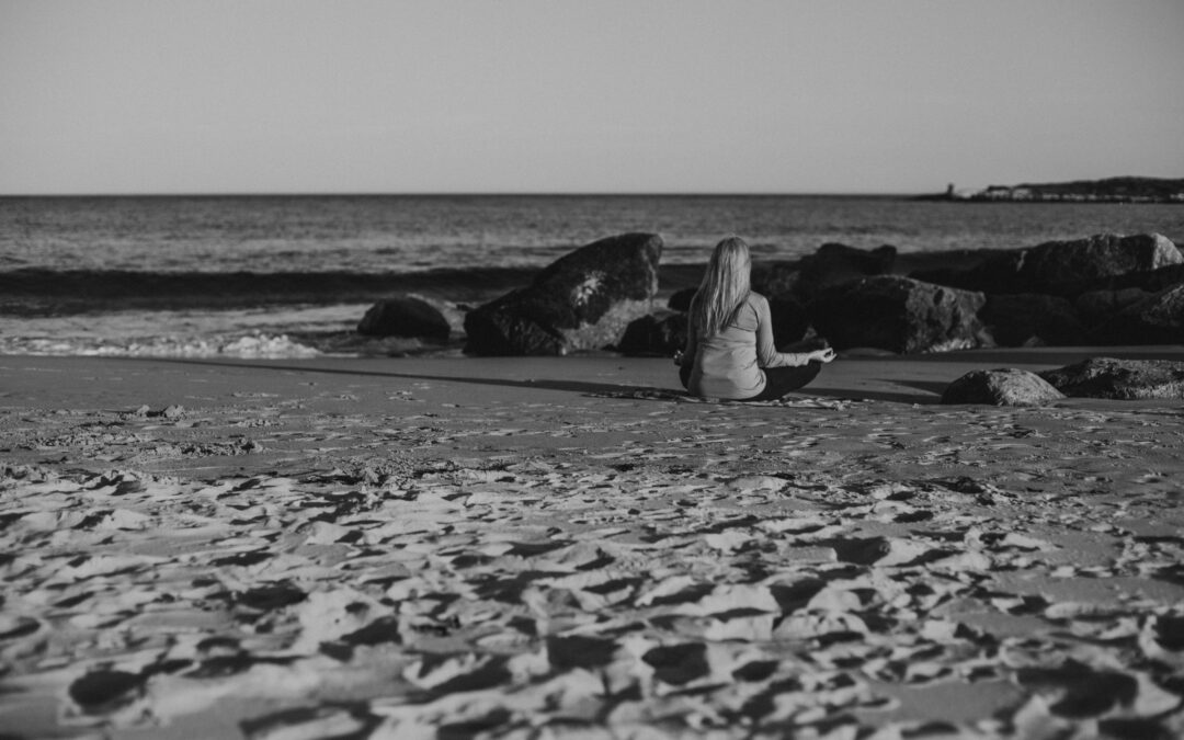 Woman meditating on the beach