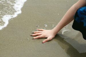 Hand on the sand at the beach.